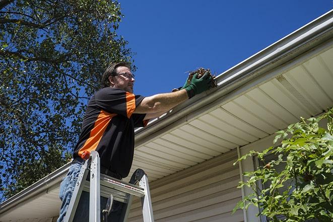 a team working together to repair a damaged gutter system in Aventura